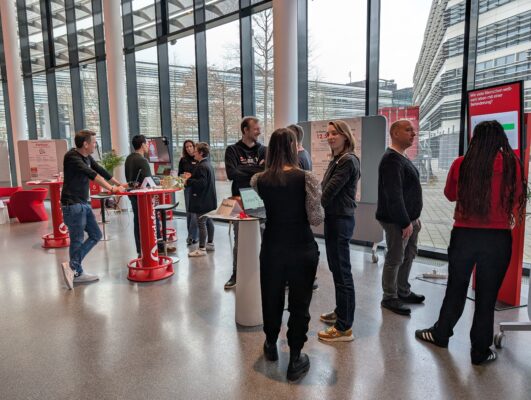 Bild der Lounge und der Parkour-Ecke. Es sind mehrere Personen im Bild, die die Angebote des Parkour-Bereichs nutzen und sich über digitale Barrierefreiheit informieren.