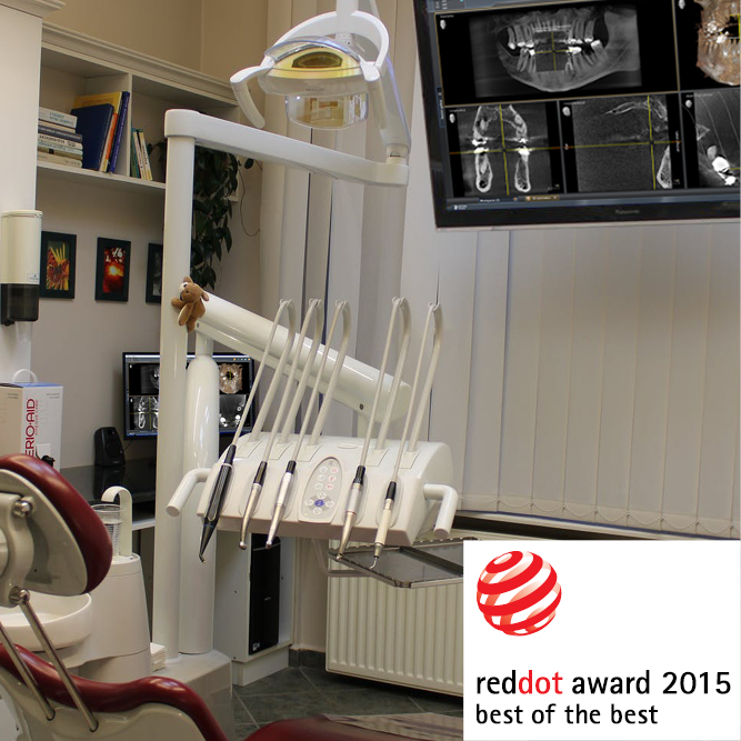 Nahaufnahme Zahnarztbehandlungsstuhl, es sind zahnmedizinische Werkzeuge sowie Monitore zu sehen, letztere zeigen die neue Software. Auch im Bild: red dot award 2015; best of the best